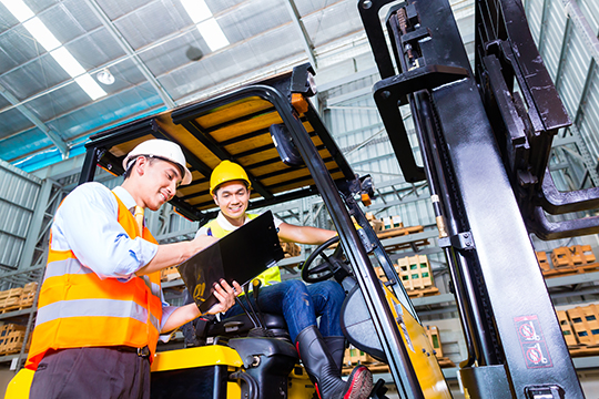 Asian lift truck driver and foreman in storage Asian fork lift truck driver discussing checklist with foreman in warehouse